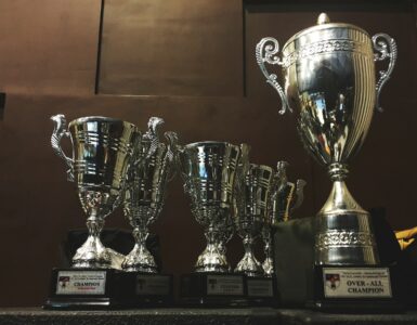 several silver and gold trophies on wooden surface